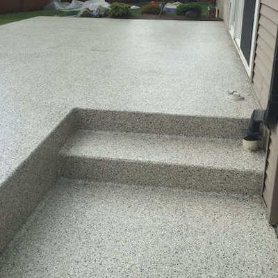 Light grey polyaspartic coating on deck surrounding with steps at back of house