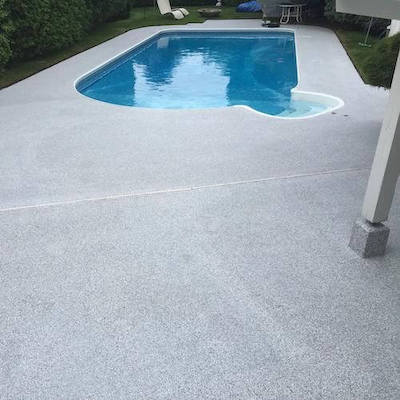 Light grey polyaspartic coating on deck surrounding swimming pool